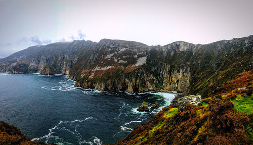 Scenic view of sea and mountains against sky