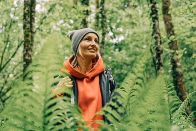Portrait of a young wellness woman hiker in a thicket of ferns in a spring forest