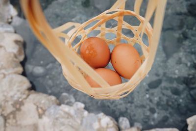 Close-up of eggs in wicker basket hanging over pond