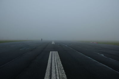 View of airport runway against sky during foggy weather