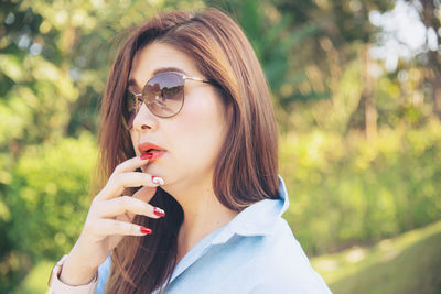 Portrait of beautiful woman holding sunglasses