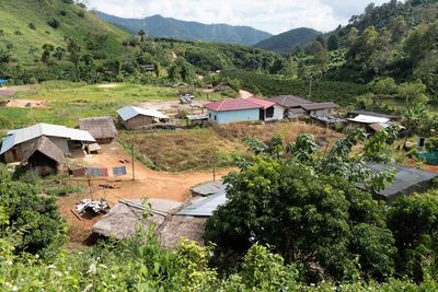 High angle view of houses and trees against mountains