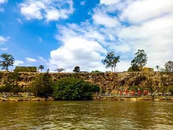 Scenic view of river by trees against sky