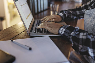 Close-up of manager using laptop at bar counter