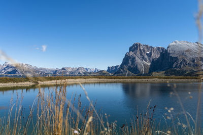 Scenic view of lake and mountains against blue sky