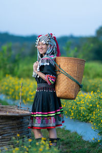 Woman holding umbrella while standing on field