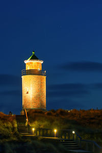 Illuminated lighthouse against sky at night