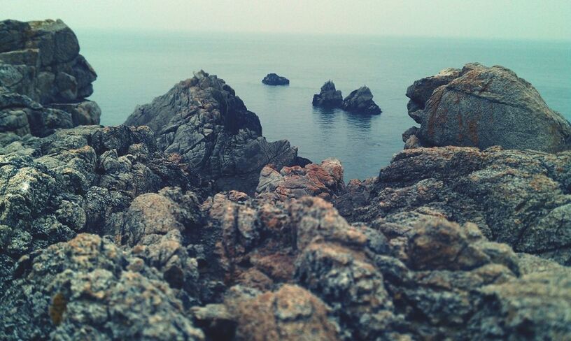 sea, horizon over water, water, rock formation, rock - object, tranquil scene, tranquility, scenics, beauty in nature, rock, nature, cliff, idyllic, sky, beach, shore, rocky, outdoors, rough, geology