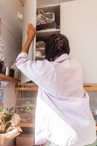 Woman reaching out to the cupboard at home