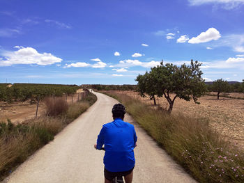 Rear view of man on road against sky