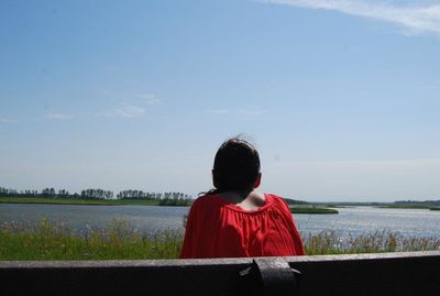 Rear view of woman looking through window