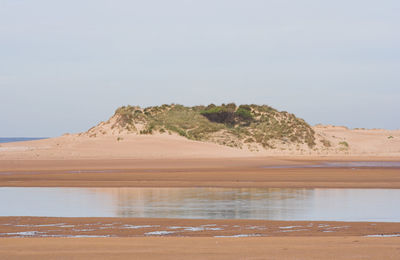 Scenic view of beach against clear sky