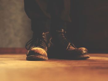 Low section of man wearing boots standing on floor