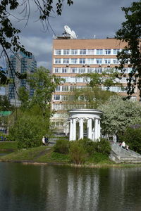 Building by lake against sky