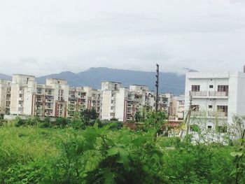 Buildings in city against cloudy sky