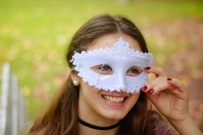 Smiling young woman wearing venetian mask