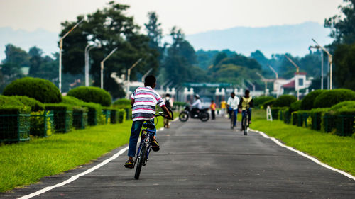 Rear view of man riding bicycle on road