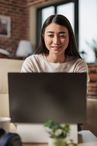 Businesswoman using laptop at home