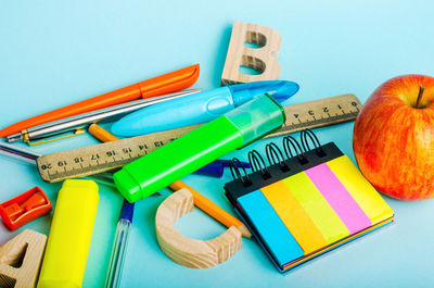 Letters, apple, ruler, pens, scissors, colored markers, pencils, sticky stickers, sharpener