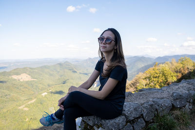 Portrait of young woman sitting on mountain