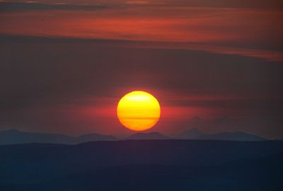 Scenic view of silhouette mountains against sky during sunset