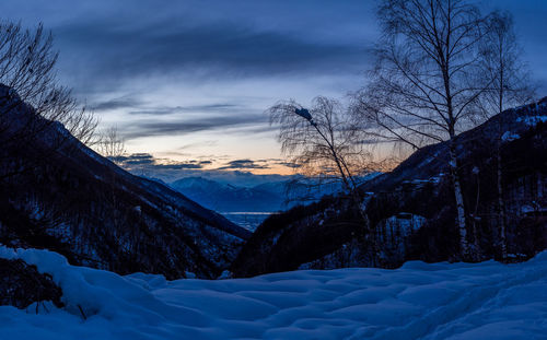 Scenic view of snow covered mountains against sky at sunset