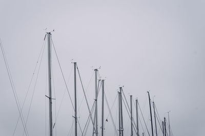 Low angle view of masts against clear sky