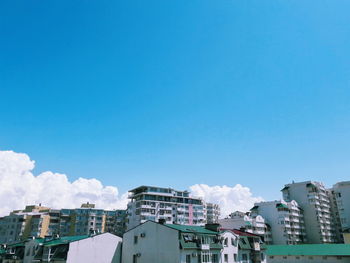 Buildings in city against blue sky