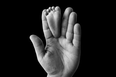 Close-up of human hand against black background