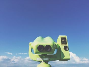 Close-up of coin-operated binoculars against blue sky