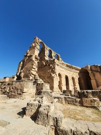 Low angle view of old ruins against blue sky