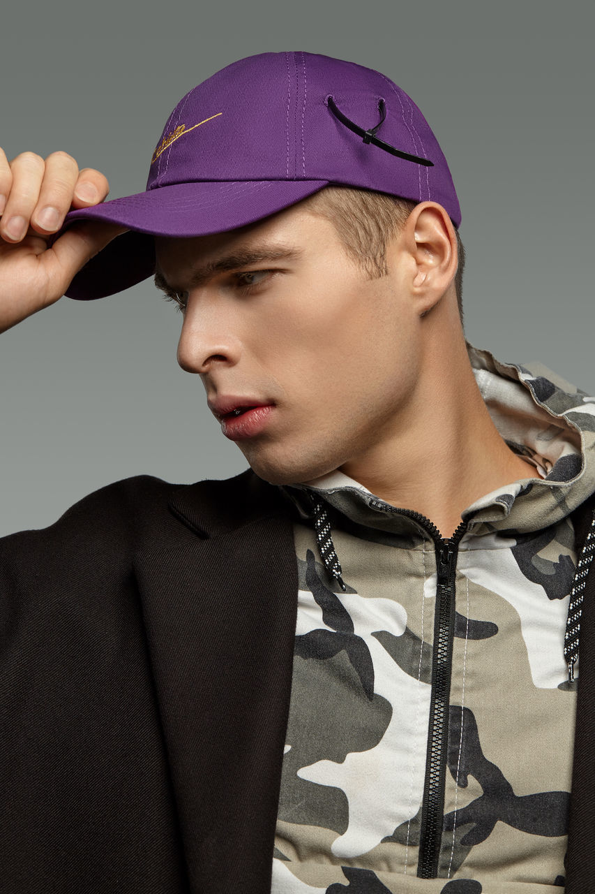 PORTRAIT OF YOUNG MAN LOOKING AWAY WHILE STANDING ON CAMERA