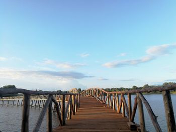 Wooden pier over sea against sky