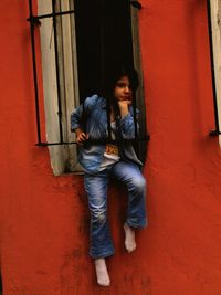 Portrait of young couple standing against wall