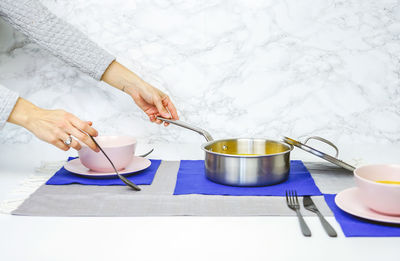 Cropped hands of woman having food at home