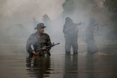 Soldiers walking on river