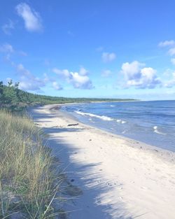 View of calm beach against blue sky