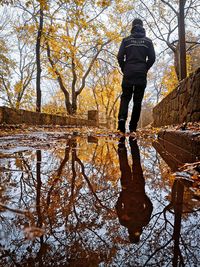 Rear view of man standing by lake