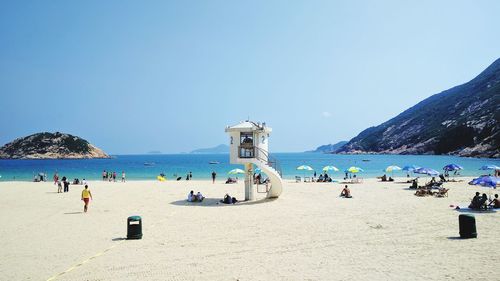 Panoramic view of people on beach against clear sky