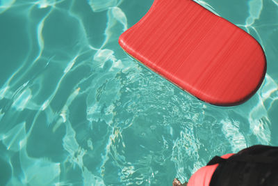 High angle view of red pool raft floating on swimming pool during sunny day