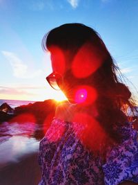 Close-up of woman against sky during sunset