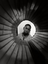 Boy looking away seen through pipe