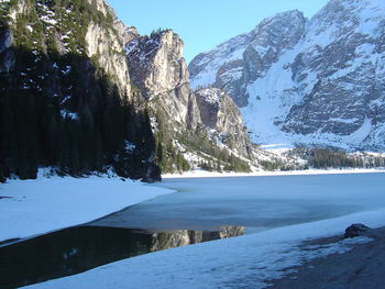 Scenic view of rocky mountains by lake during winter
