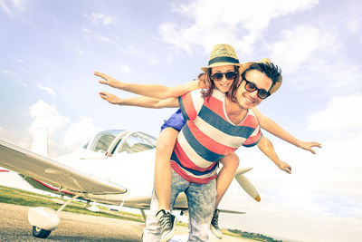 Portrait of smiling young friends against sky