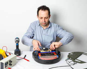 Portrait of man holding camera on table