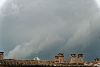 High section of buildings against cloudy sky