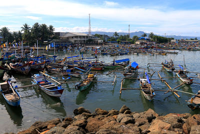 Boats moored on shore against sky