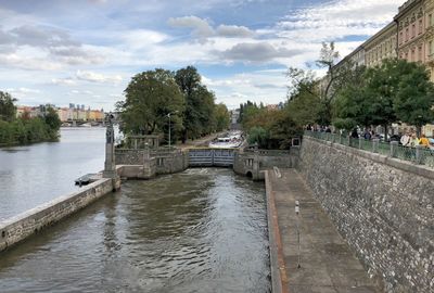 Bridge over river in city against sky