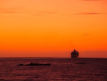 Scenic view of sea against orange sky