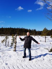 Full length portrait of man standing on snow field